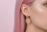 Boucles d’oreilles cœur solaire rayonnant portées, style minimal et élégant